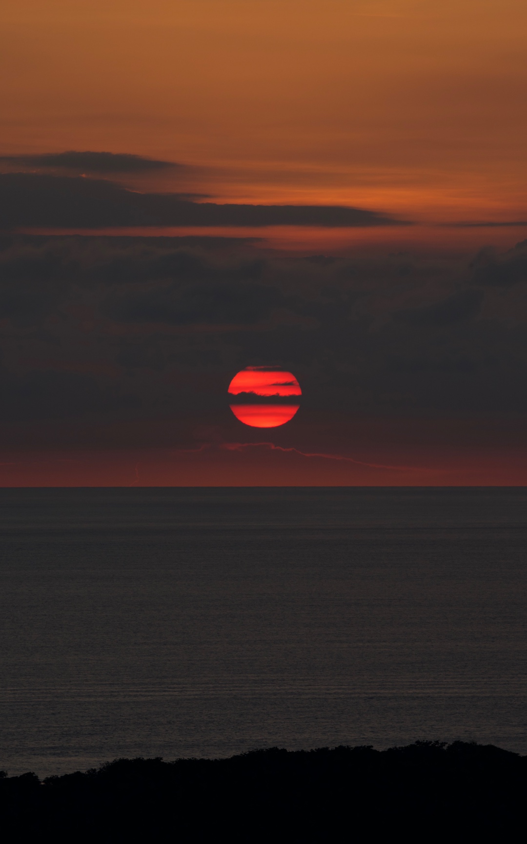Deep red sun setting over the Pacific Ocean